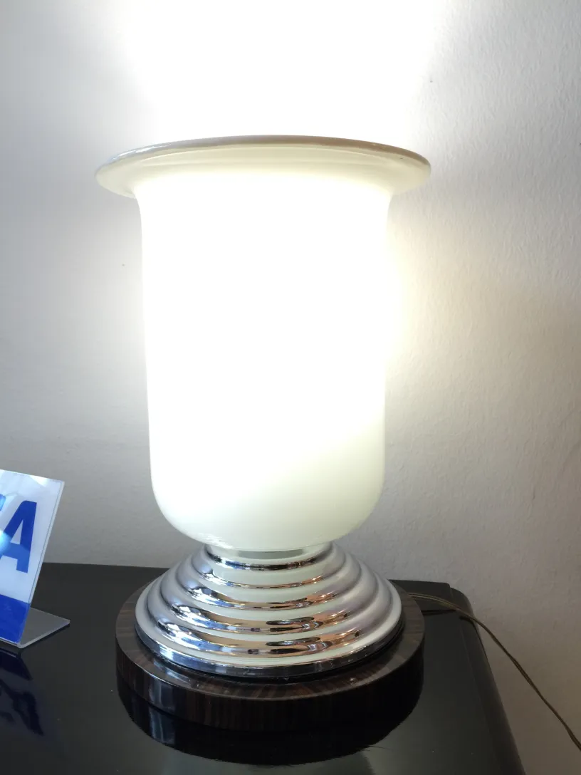 Due lampade da tavolo antiche illuminano un ambiente moderno, con base rotonda e paralume bianco.