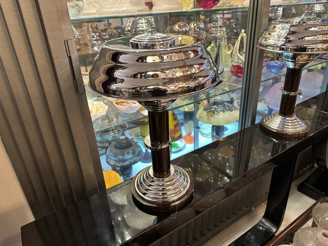 两个古董檯燈，底座闪亮，置于装饰环境中。