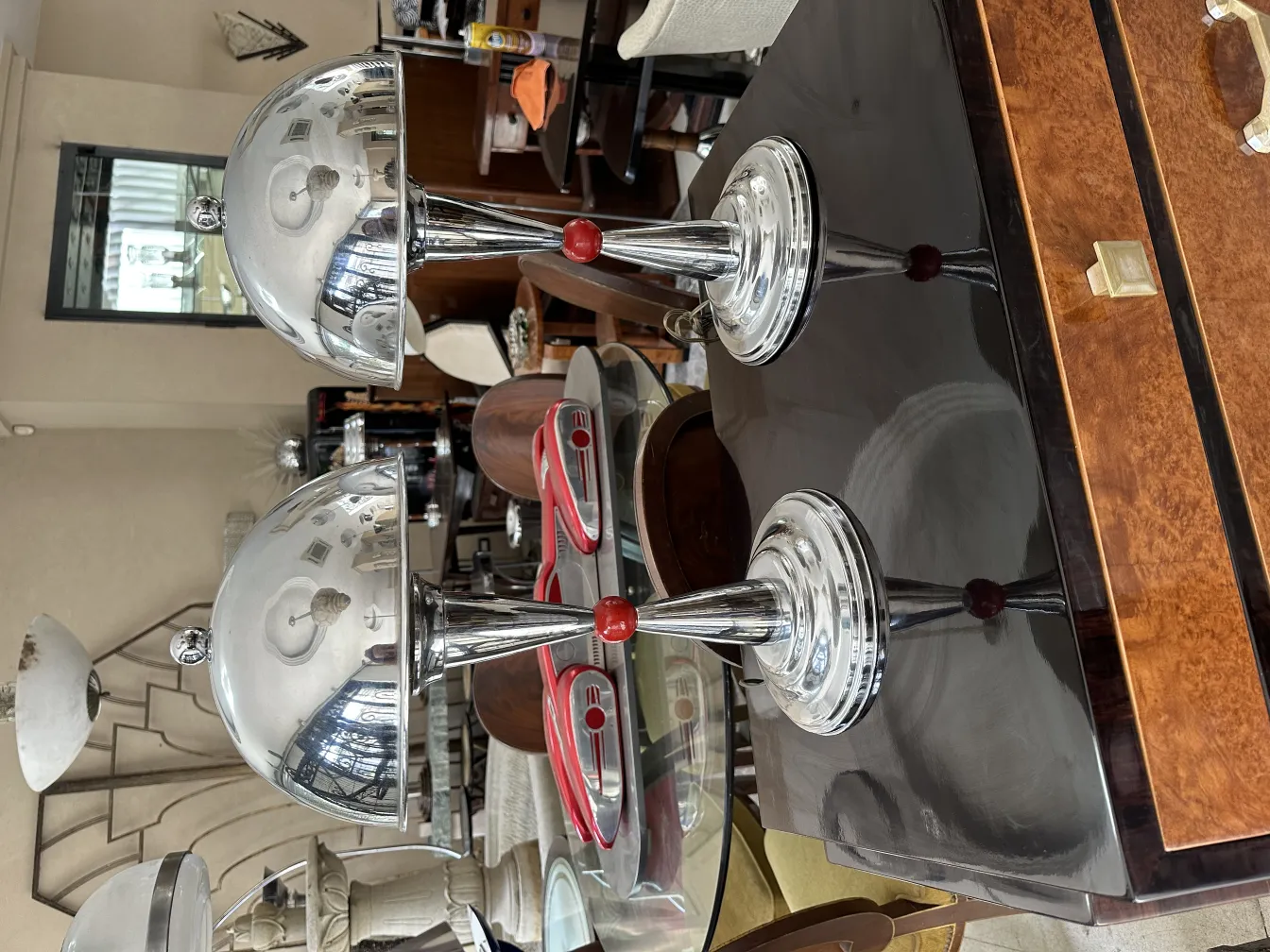 vista frontal de 2 lampadas de mesa antigas com bases brilhantes em uma mesa