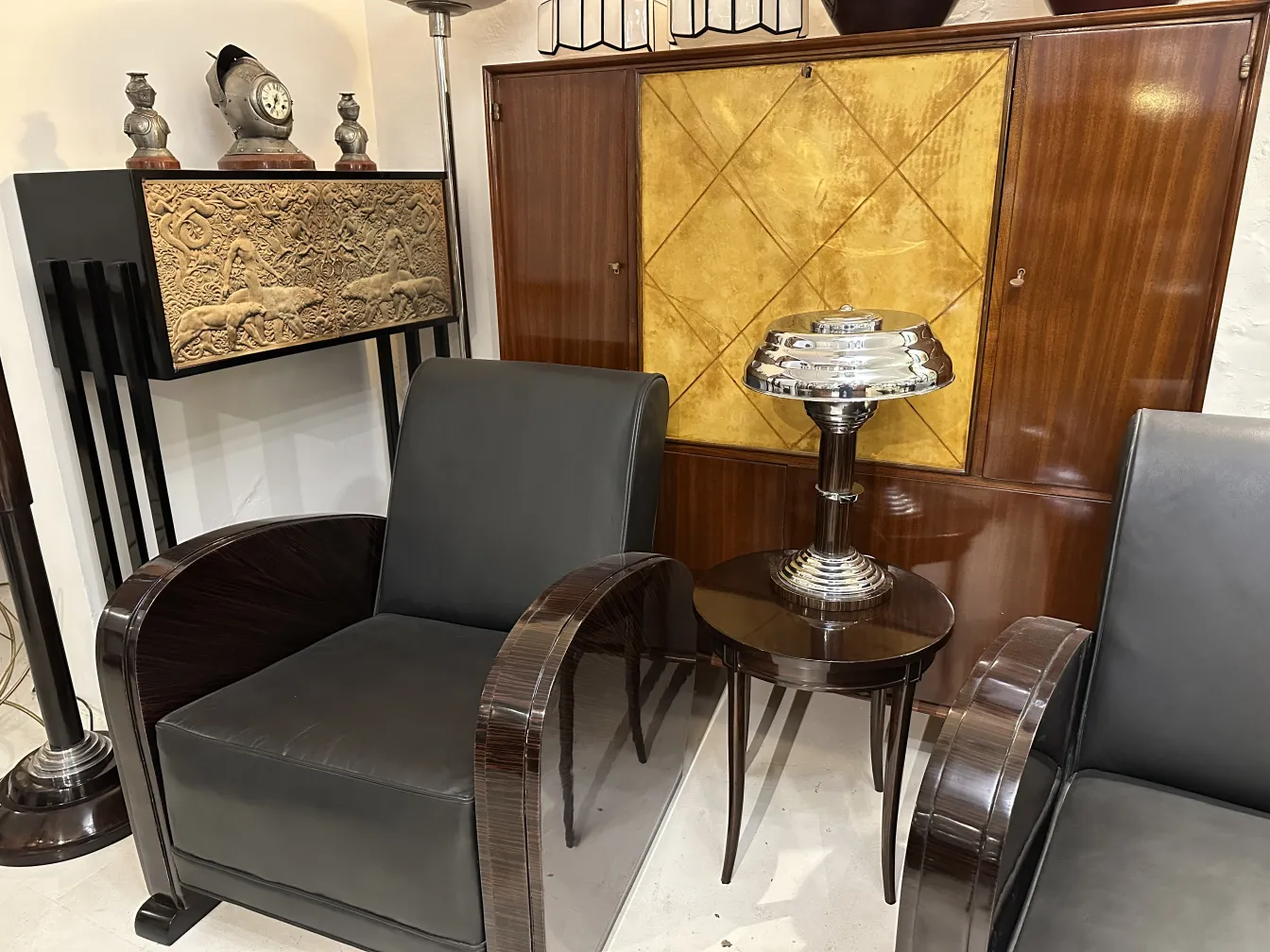 Two antique table lamps against a stylish setting with chairs and background decoration.