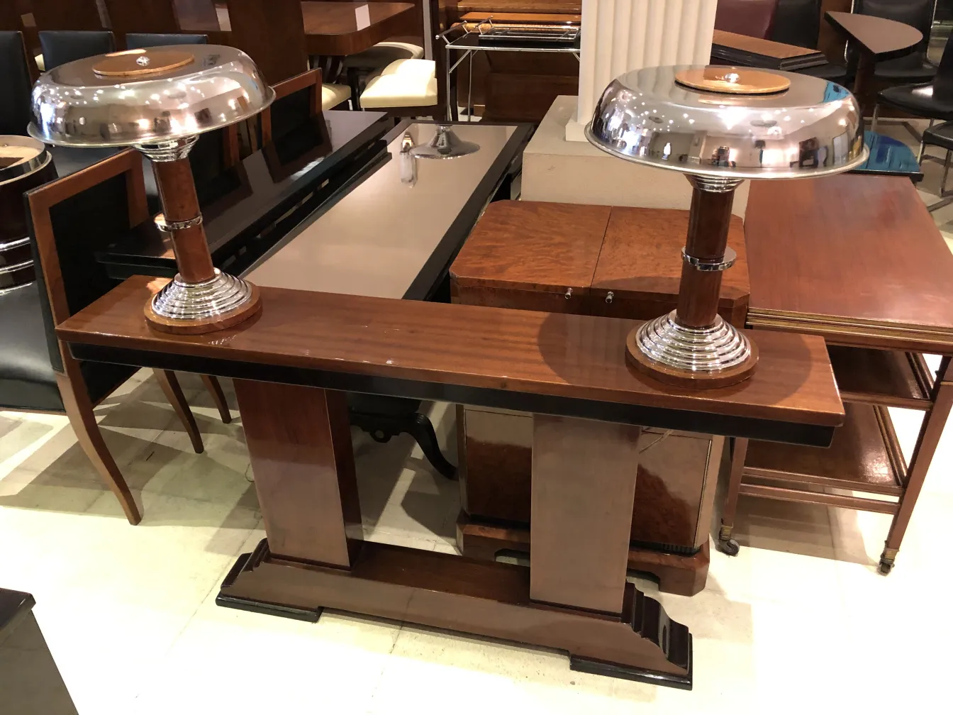 Two antique table lamps with shiny bases in a furniture setting