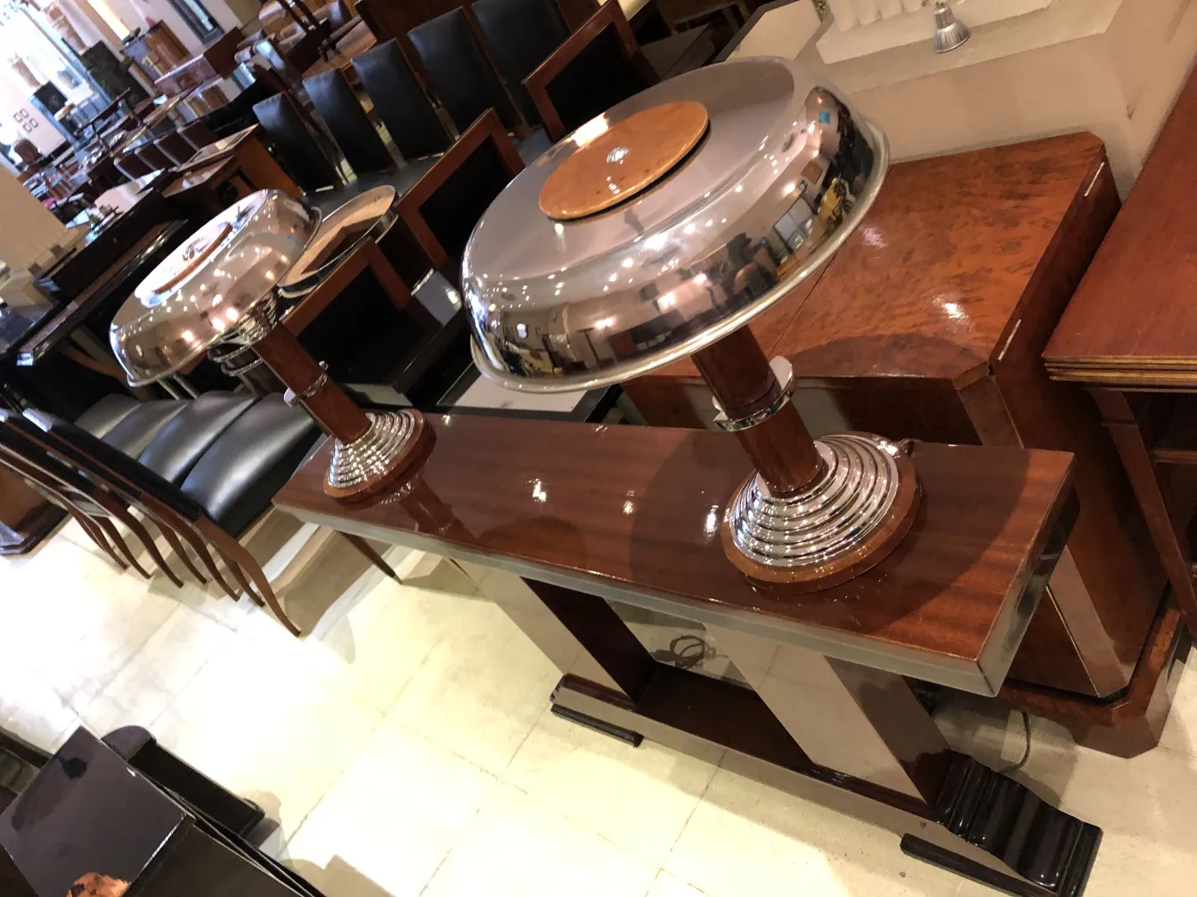 two antique table lamps with shiny bases, in an elegant setting, surrounded by vintage furniture