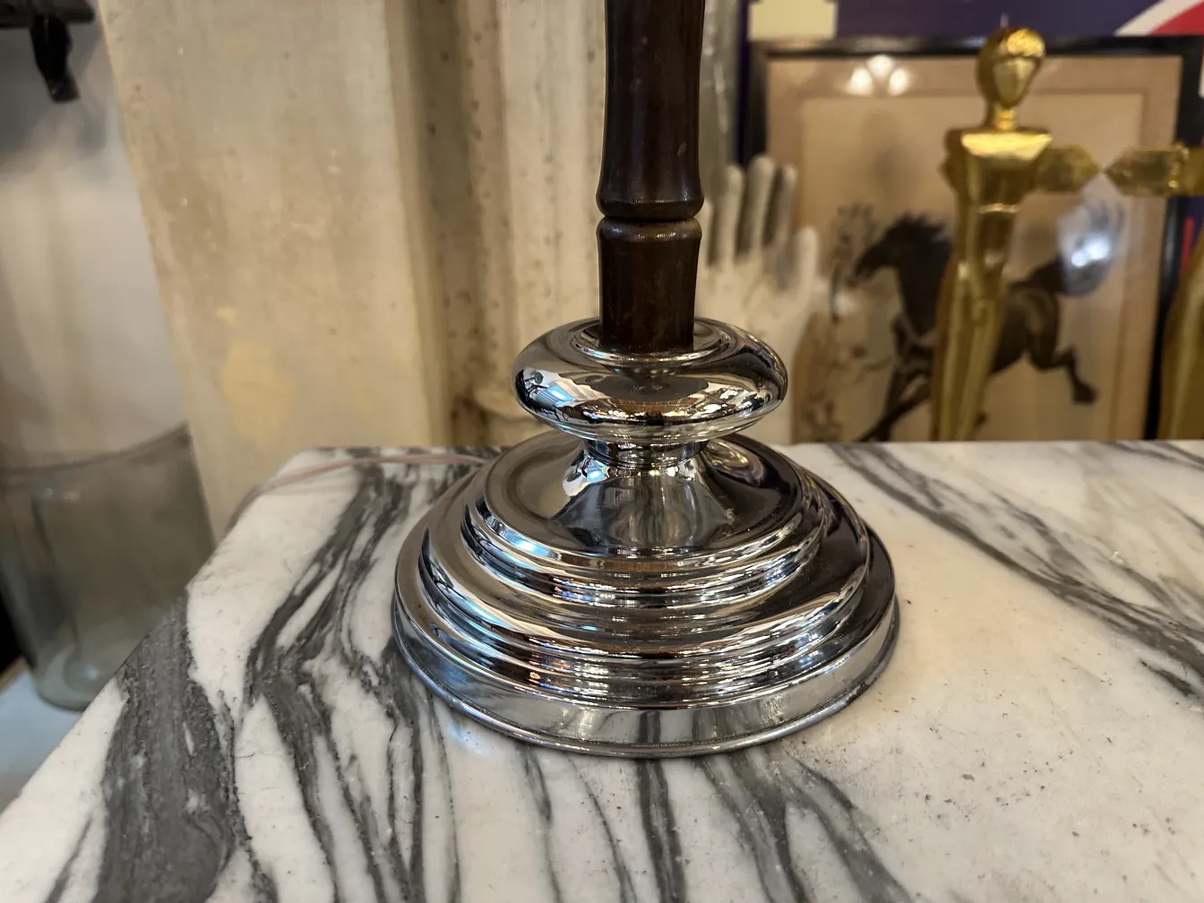 Shiny base of an antique table lamp on marble background