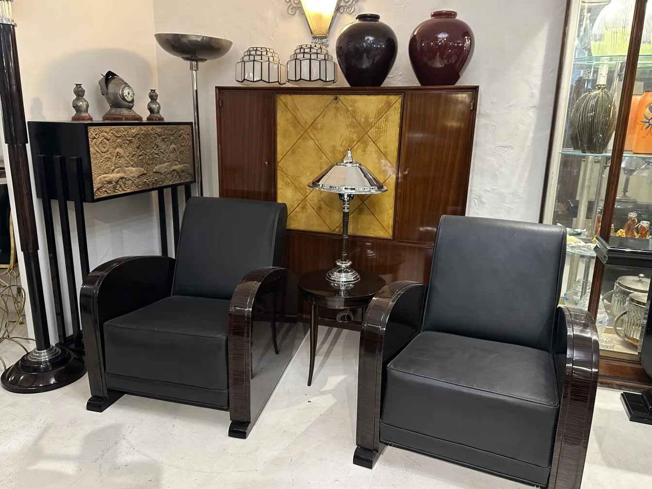 اثنان من المصابيح الطاولة الأثرية في بيئة أنيقة مع كراسي جلدية.