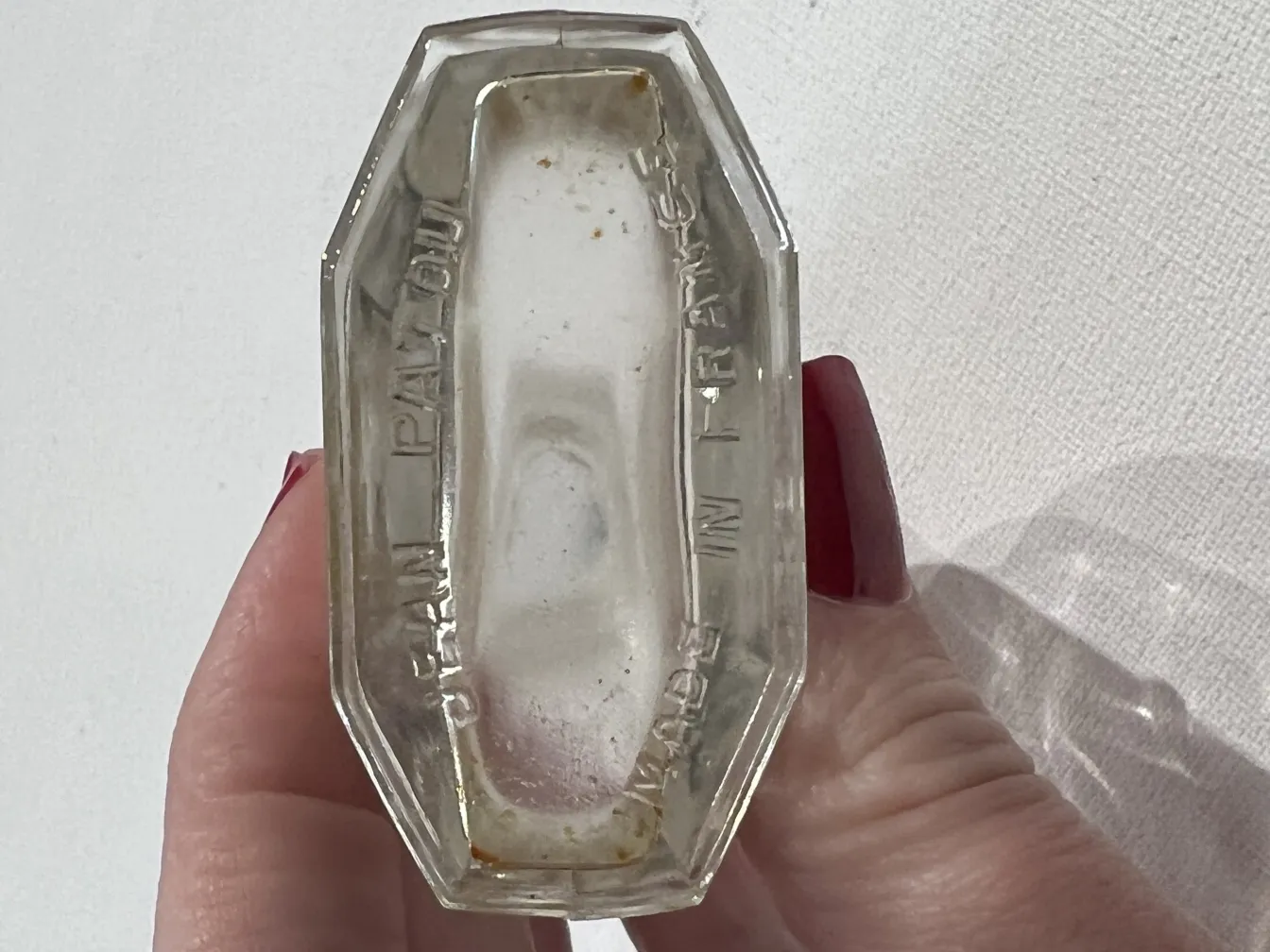 Antique perfume bottle with embossed details and visible wear.