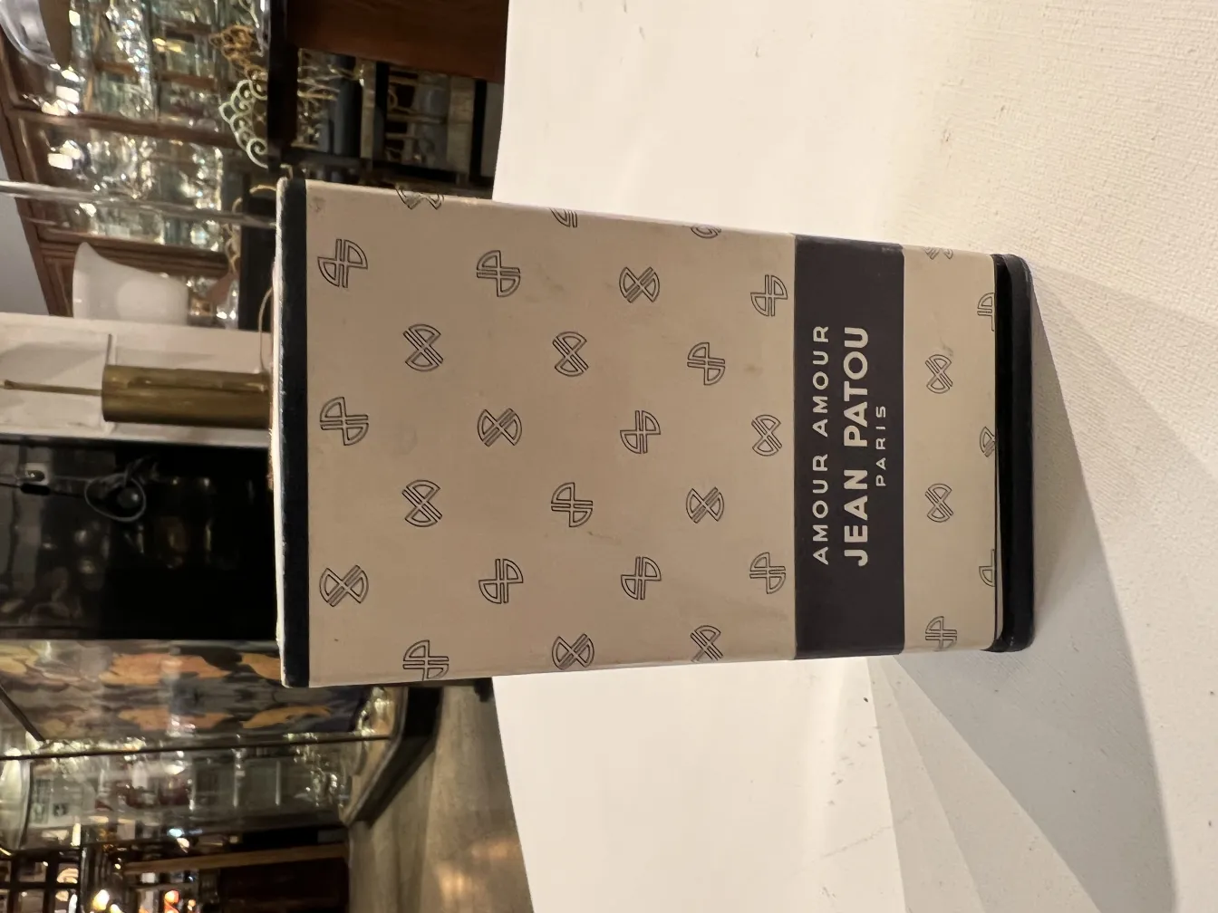 Flacone di profumo antico di Jean Patou con design elegante in un ambiente classico.