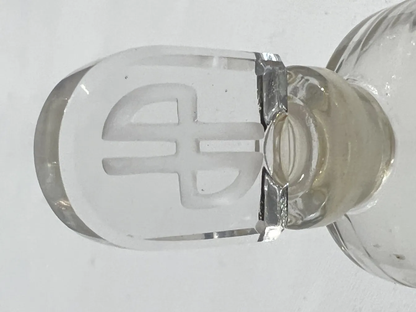 Antike Parfümflasche mit klarem Glasstopfen und elegantem Design.