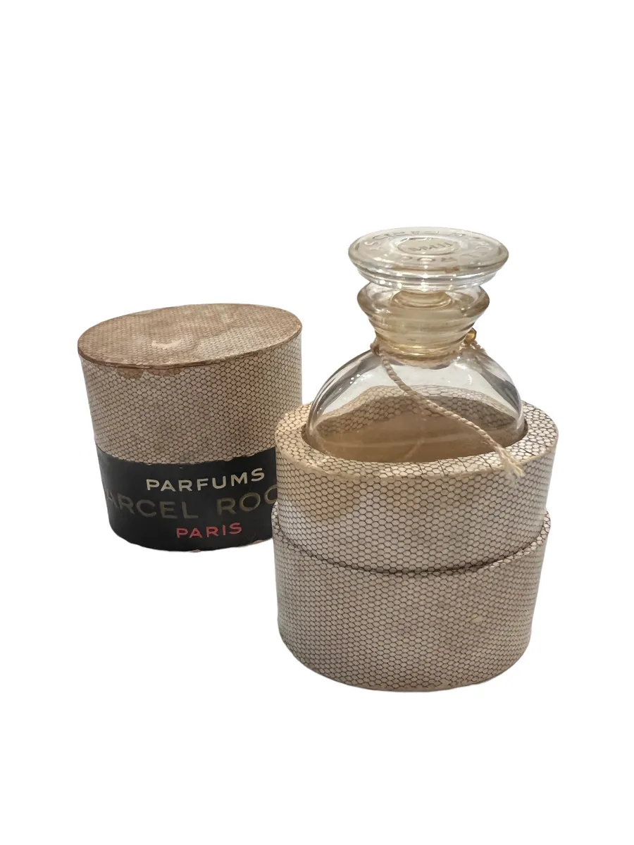 Flacon de parfum ancien avec un couvercle décoratif, enveloppé de ficelle. Présente un design élégant.