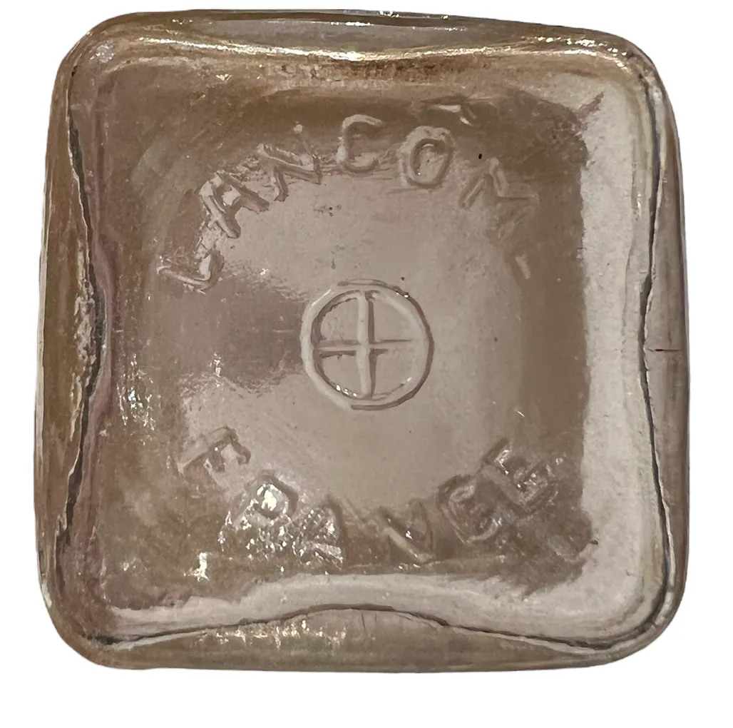 Antique Lancome perfume bottle, square and shiny, featuring details on the top.