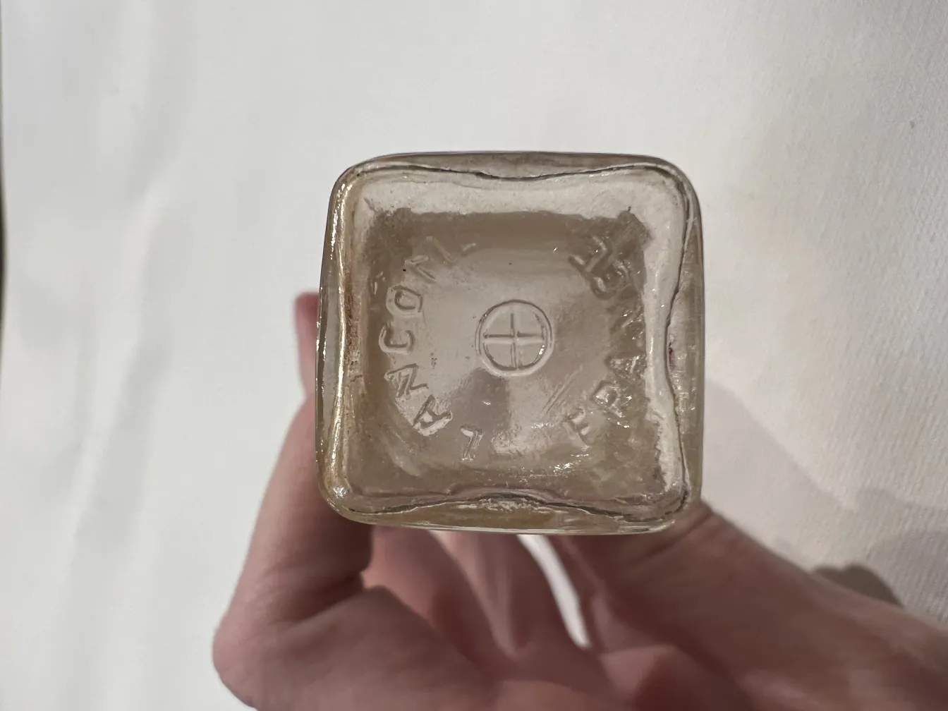 Flacone di profumo antico con dettaglio alla base, elegante e unico.