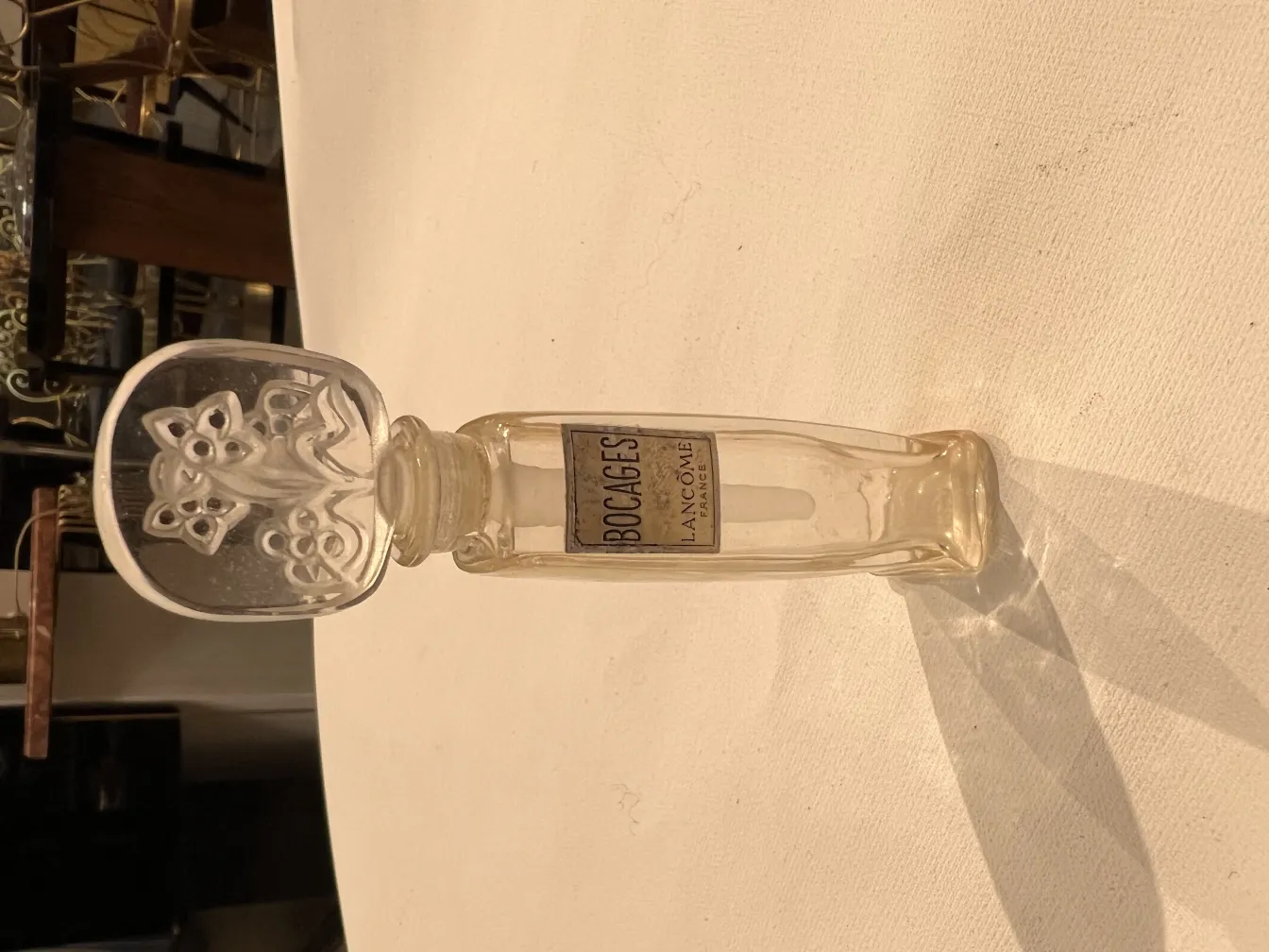 古い香水瓶花形装飾キャップ、透明なテーブルの反射