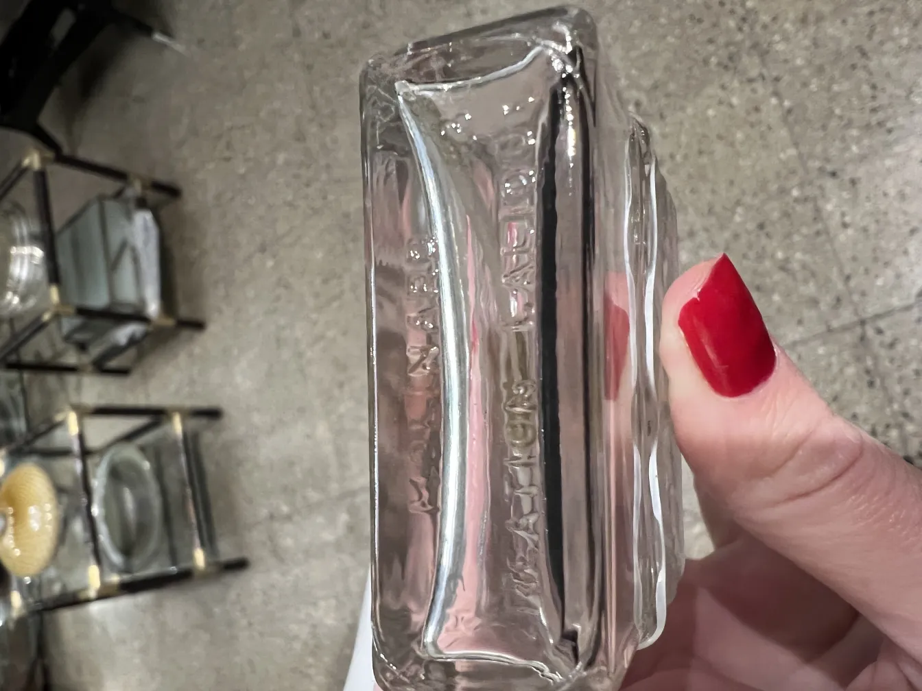 flacone di profumo antico trasparente con dettagli eleganti, sfondo con oggetti decorativi