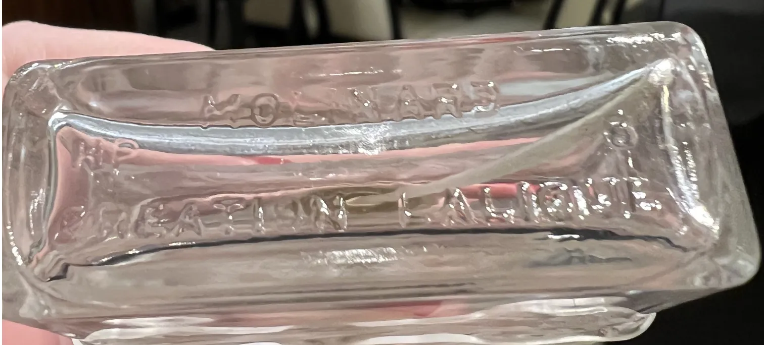 frasco antiguo de perfume transparente con detalles sutiles, ambiente elegante