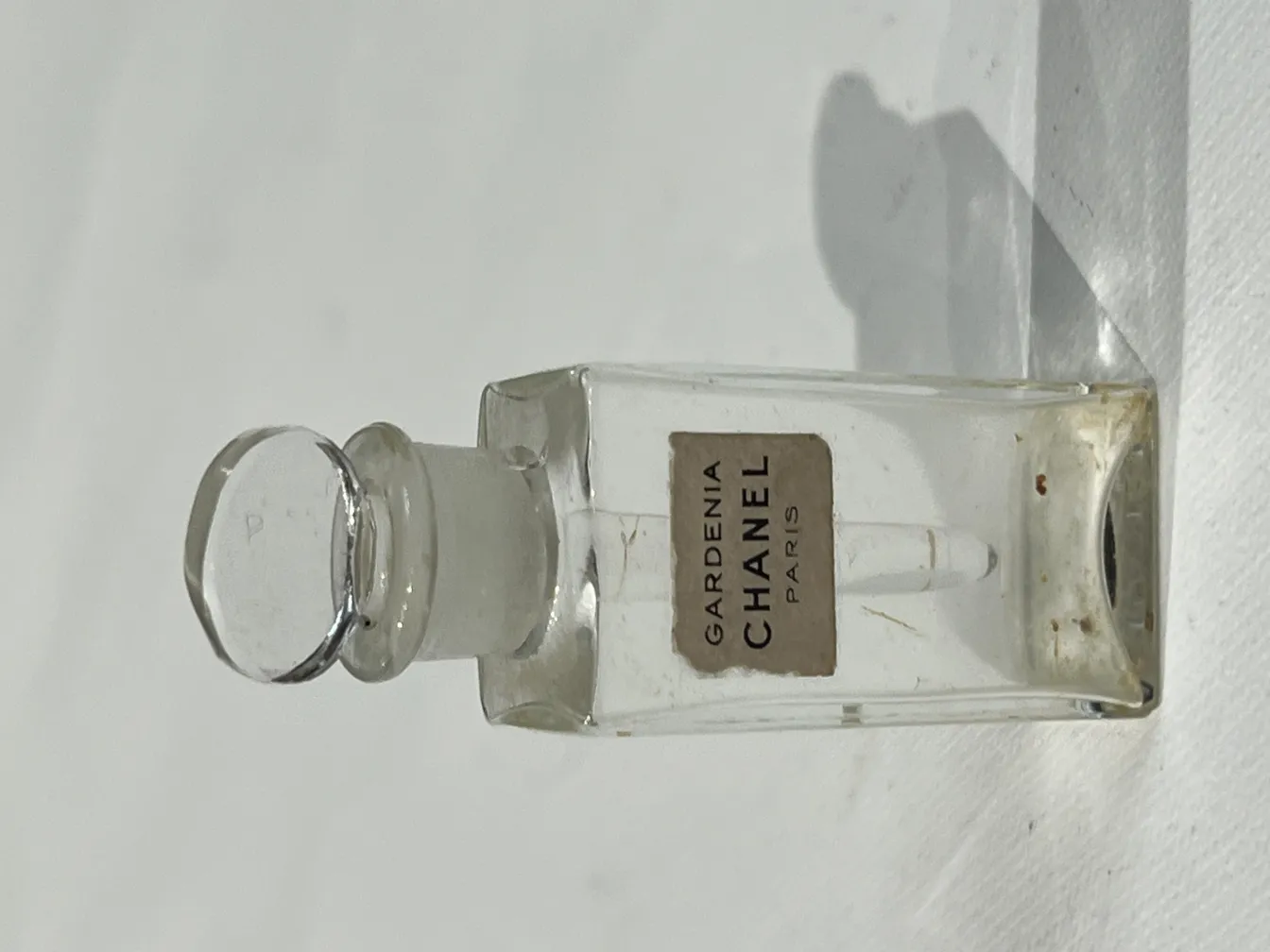 frasco de perfume antiguo de jardín, con etiqueta de Chanel, forma rectangular, transparente