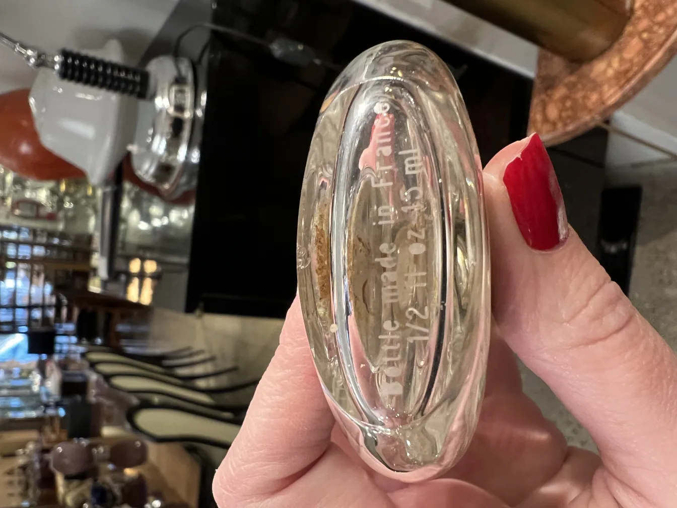 Frasco de perfume antiguo, detalles visibles, hecho en Francia, entorno elegante.