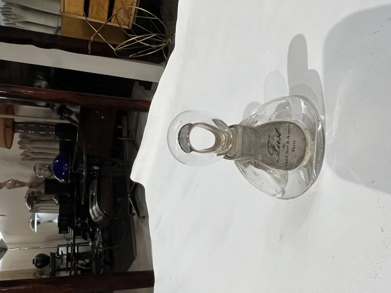 Frasco de perfume antiguo con diseño elegante en ambiente clásico.