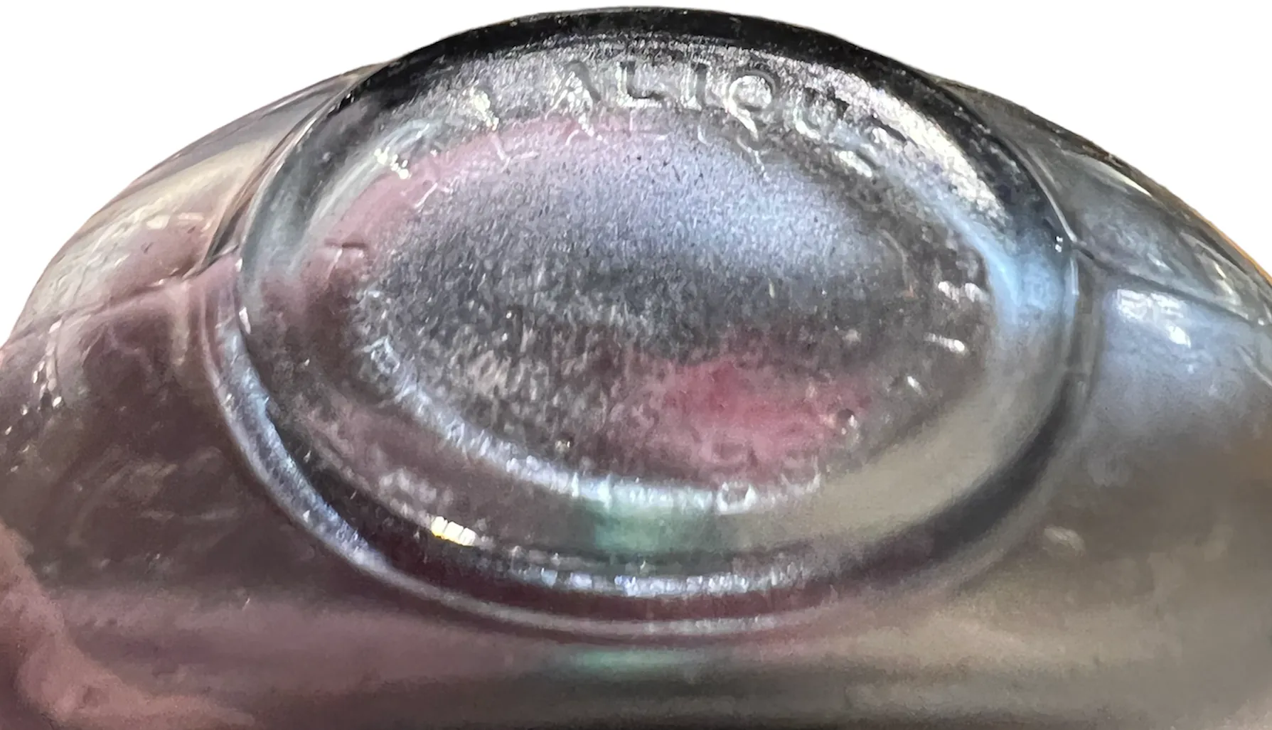 Frasco de perfume antiguo con grabado sutil en la base, detalles borrosos