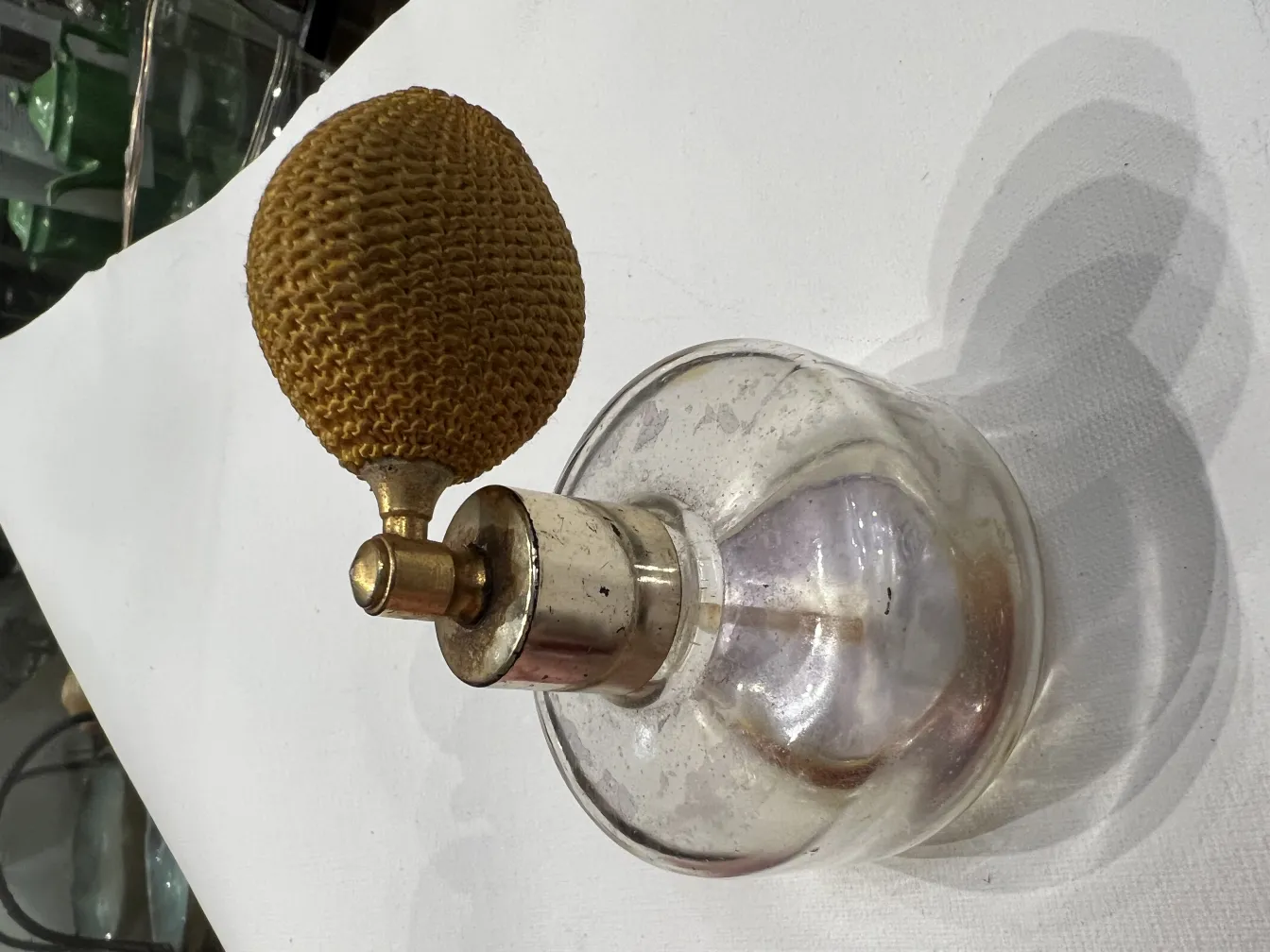 antique perfume bottle with pear-shaped dispenser, simple decoration, neutral background.