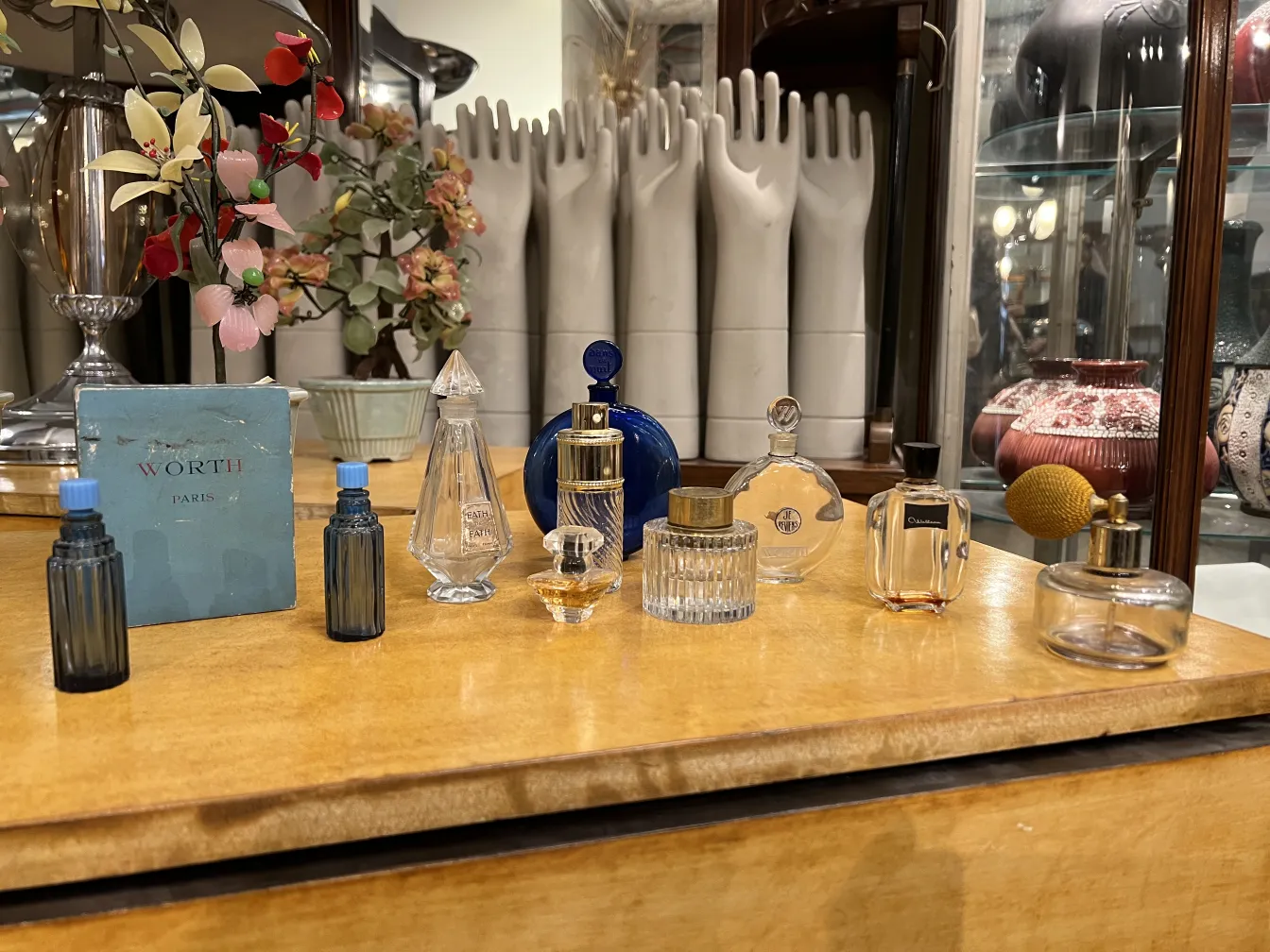 Vários frascos de perfume antigos sobre uma mesa de madeira.