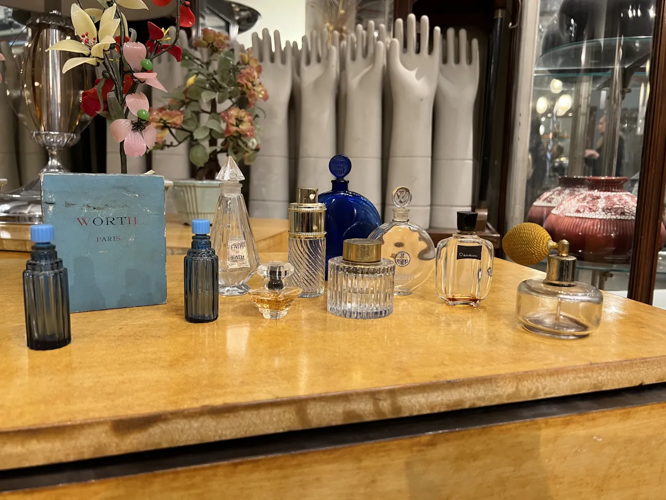 Antique decorative perfume bottles on a wooden table, with various colors and shapes.