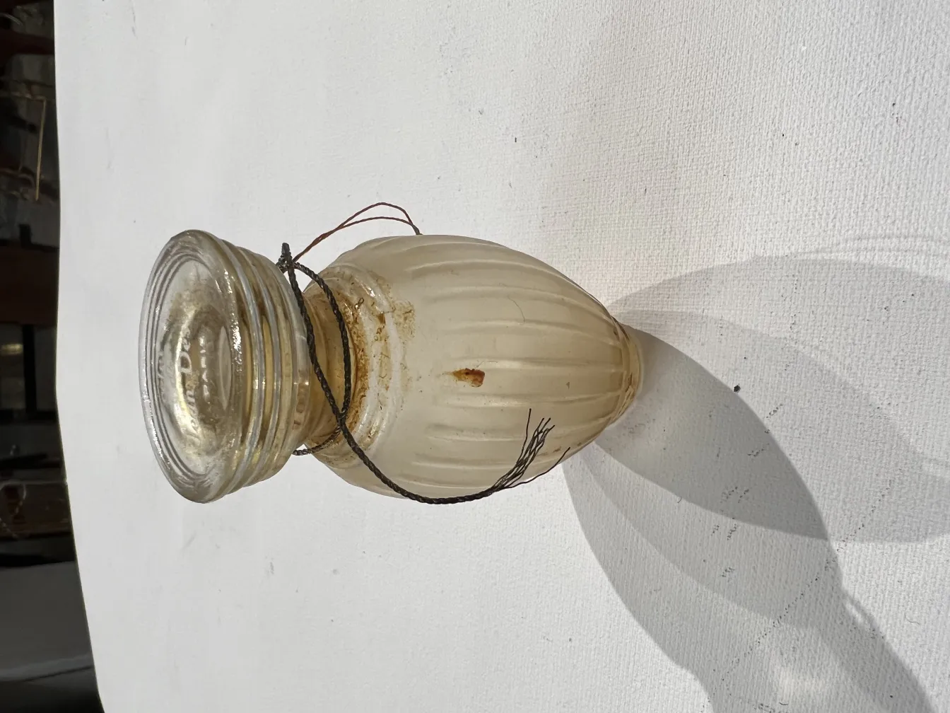 Frasco de perfume antiguo con detalles decorativos y sombra