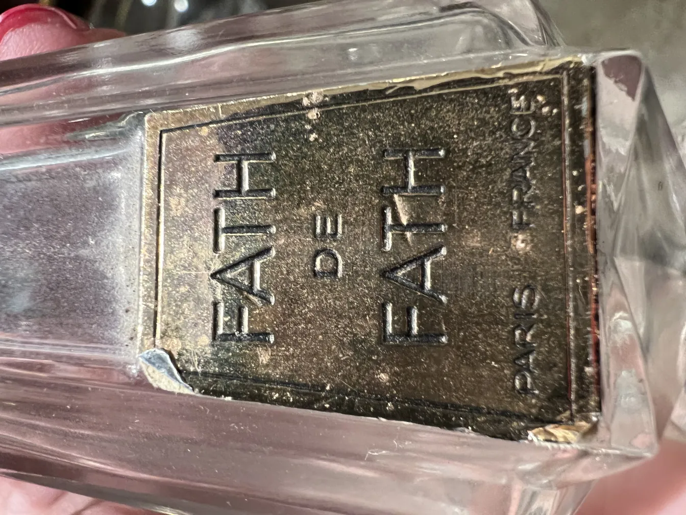 Frasco de perfume antigo de Fath em ambiente neutro.