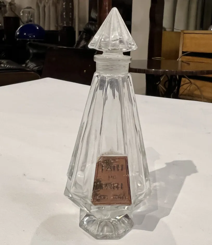 زجاجة-عطر-قديمة-بشكل-مستطيل-ومع-غطاء-هرمي-وعلقة-مرئية.