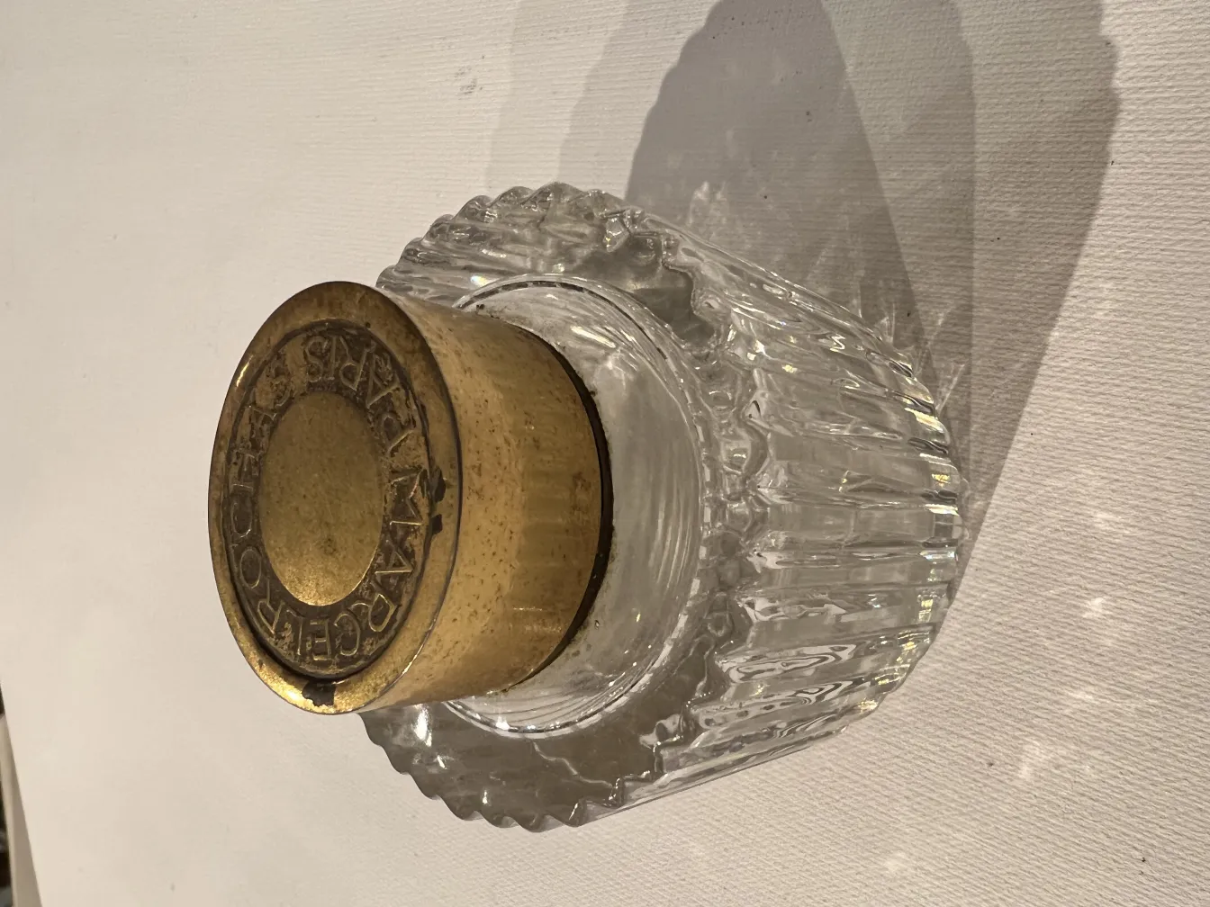 flacon de parfum ancien avec couvercle doré et design strié