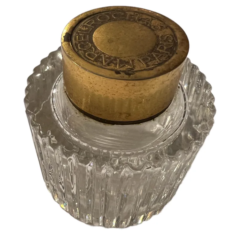 Frasco de perfume antiguo con tapa dorada y diseño estriado, decorado con relieve.