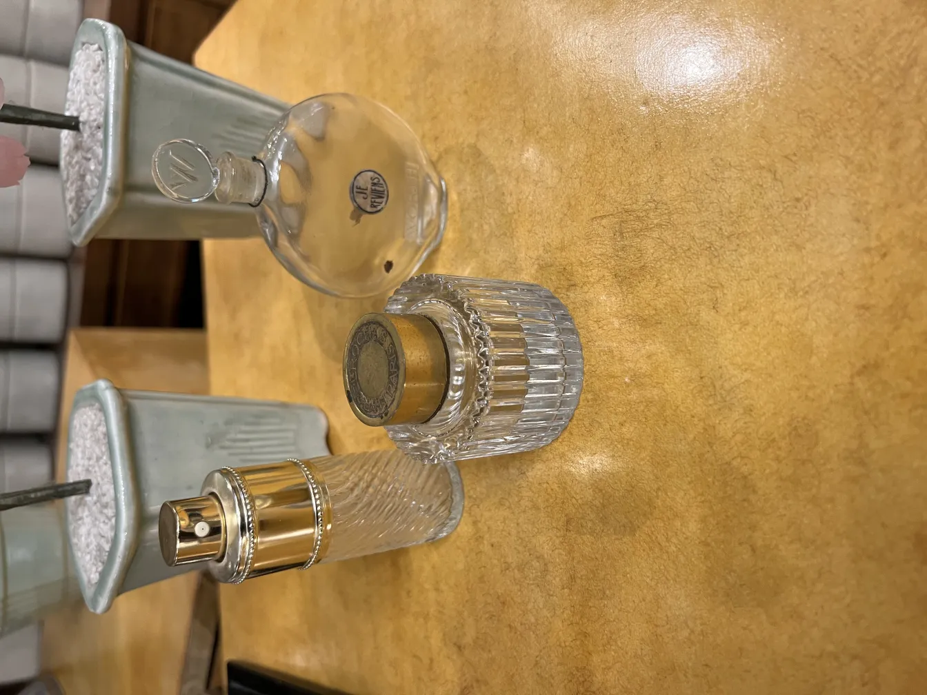 Tres frascos de perfume antiguos en una mesa de madera