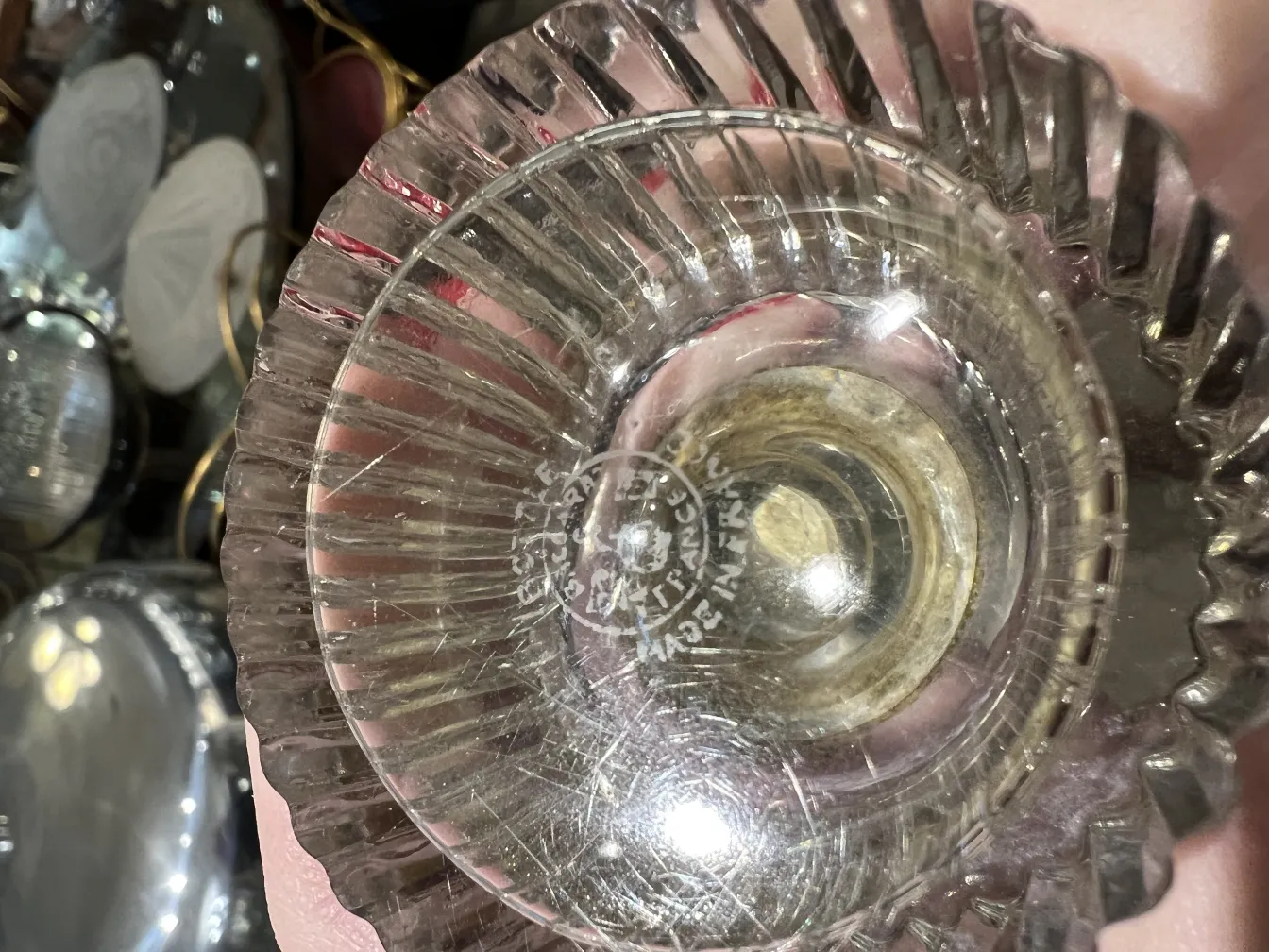 装飾的な特徴を持つ古い香水瓶が、古い物に囲まれている。