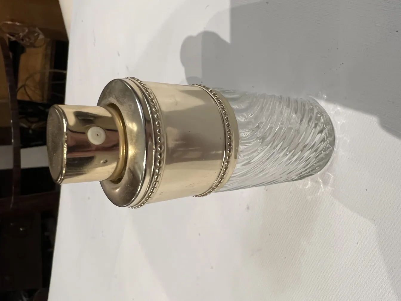 Frasco de perfume antiguo con un diseño elegante y tapa dorada.