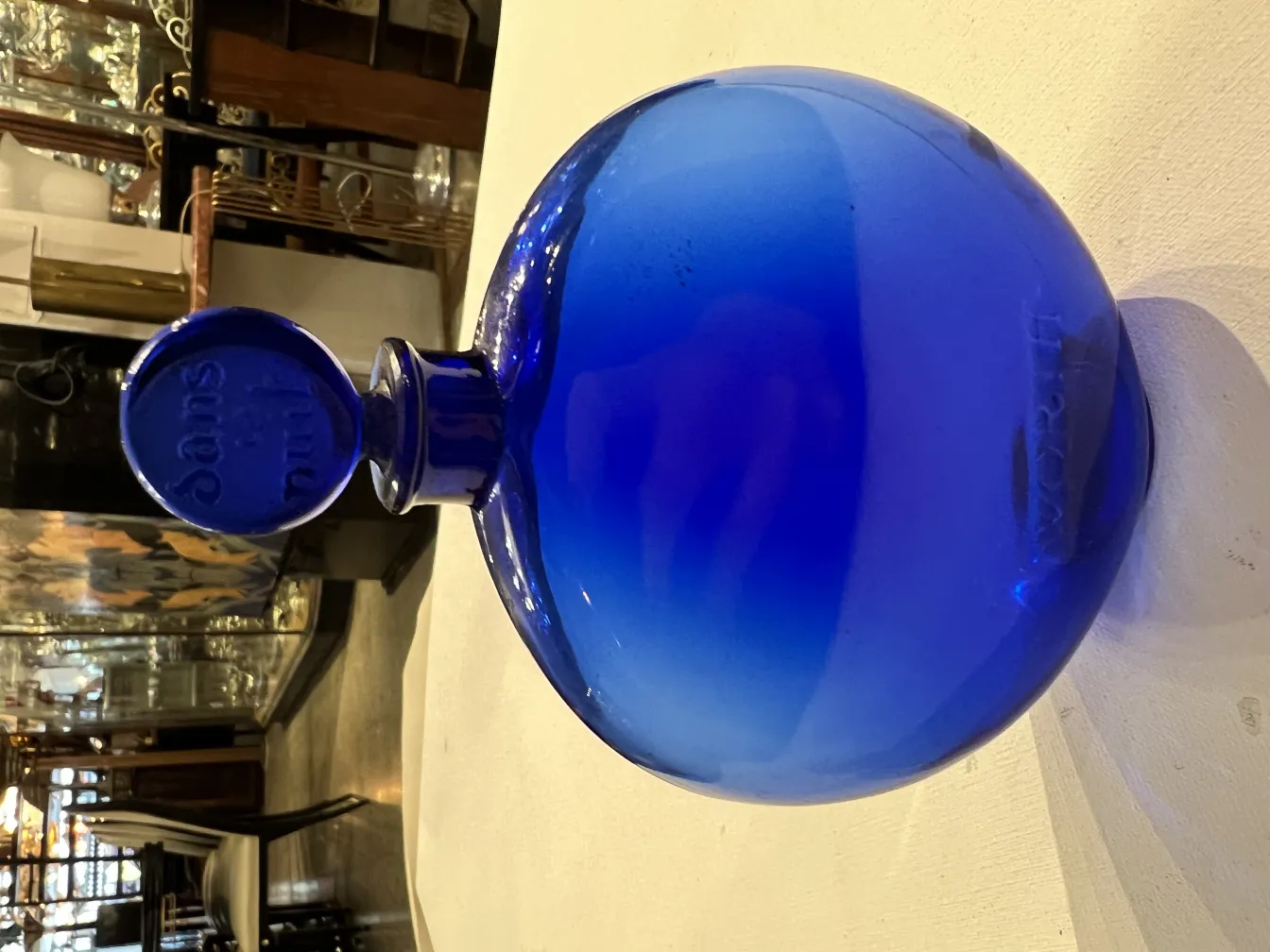antique blue perfume bottle with round top in an elegant setting