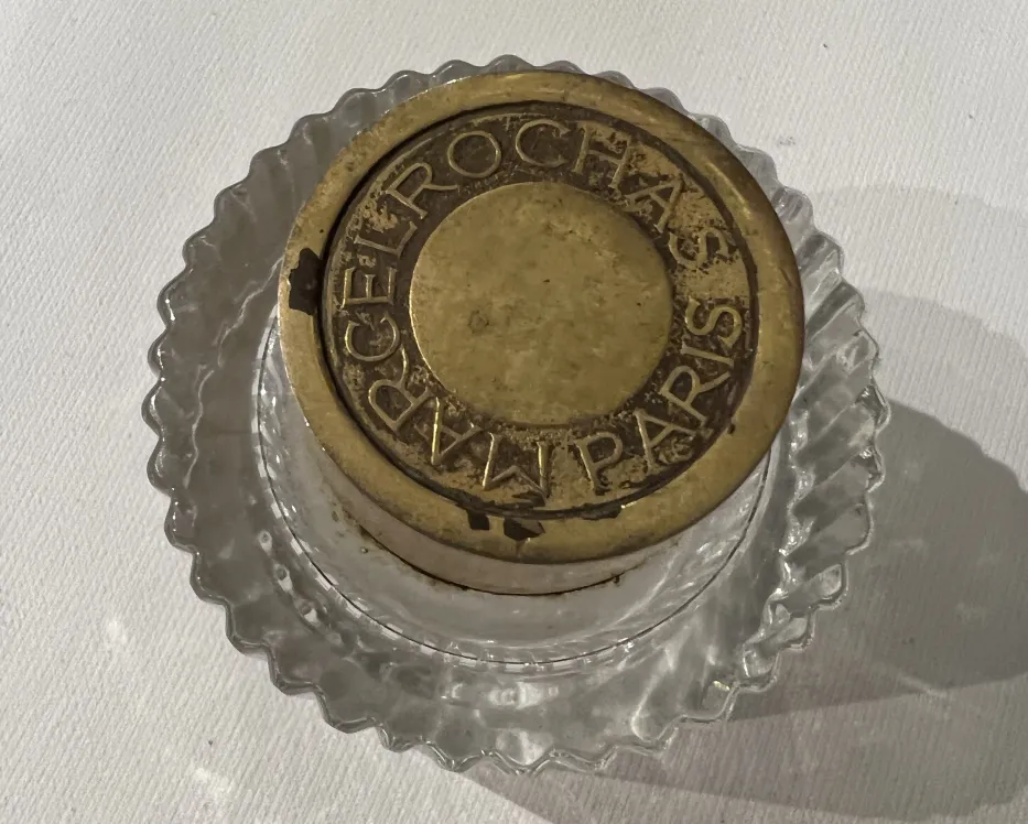 frasco antiguo de perfume con tapa dorada, fondo claro