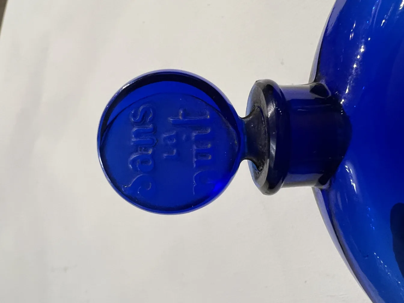 Antike blaue Parfümflasche mit runder Kappe und glattem Boden.