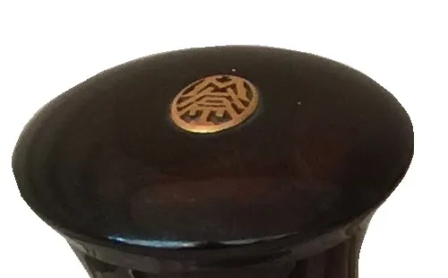 Antique perfume bottle featuring a decorative dark cap
