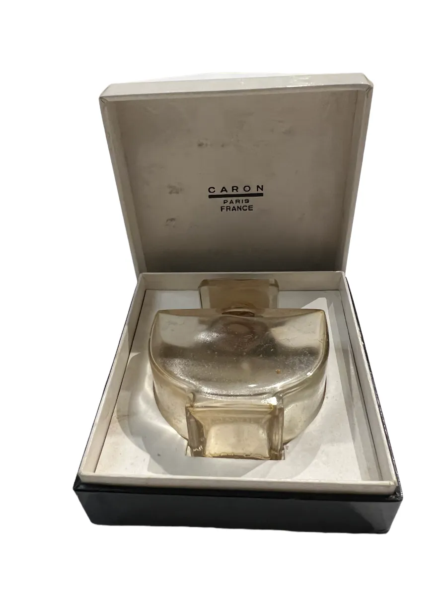 frasco de perfume antigo com tampa elegante, dentro de uma caixa