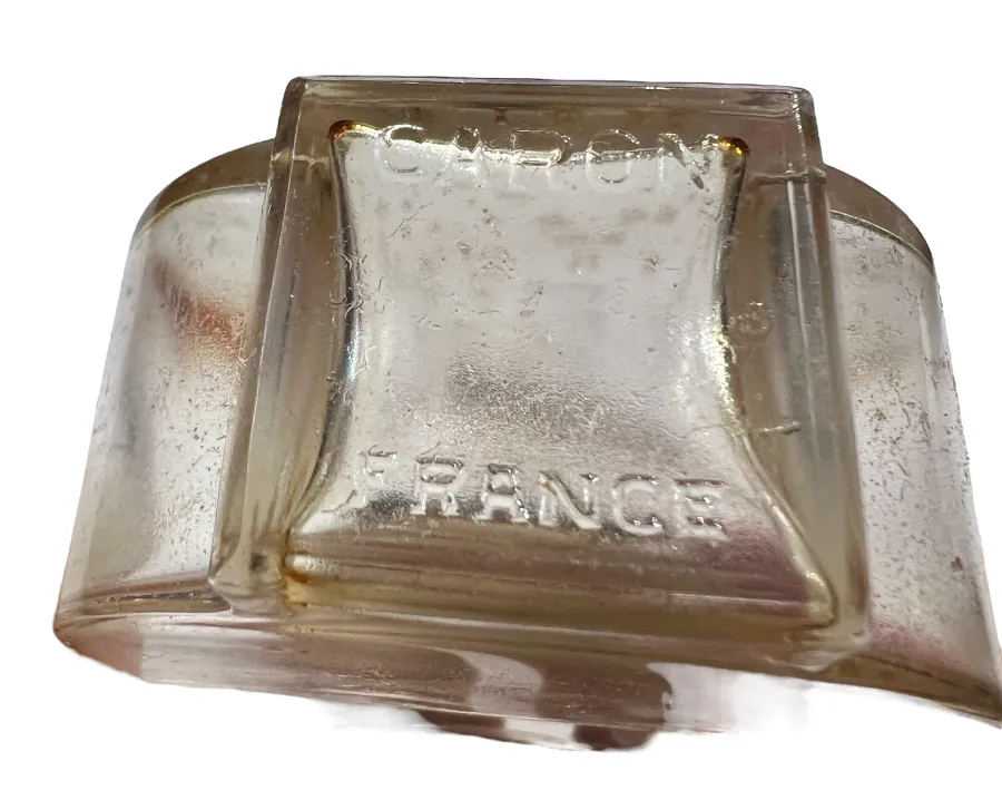Flacon de parfum ancien avec des inscriptions sur la surface, design unique.