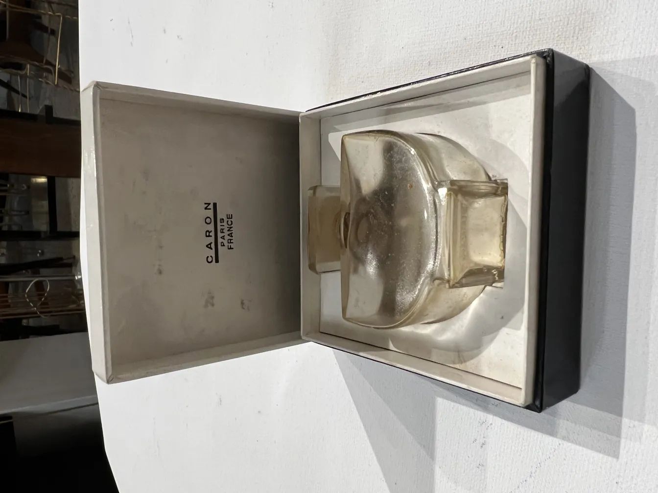 古い香水瓶、ガラスの蓋が付いていて、シンプルな箱に置かれている