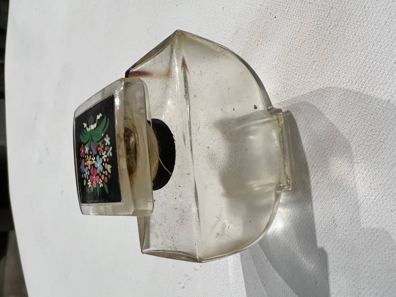 frasco de perfume antigo com tampa decorativa e flores