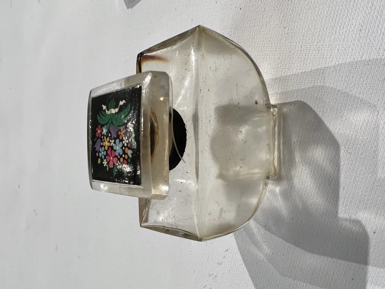 antique perfume bottle with decorated cap and flowers