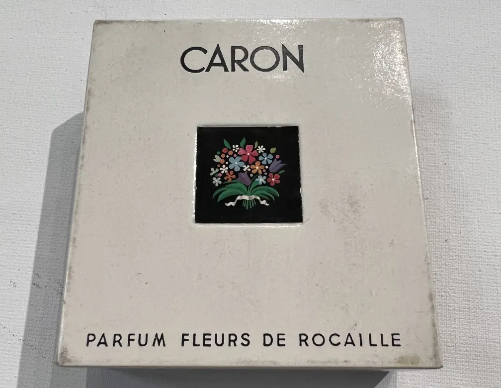 antique perfume bottle with floral design and Caron logo