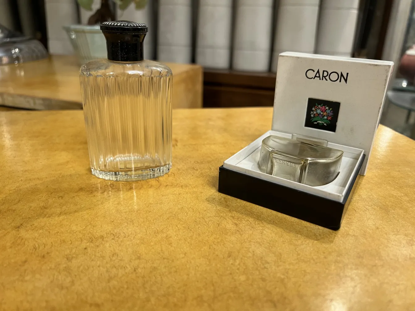 flacone di profumo antico con tappo nero in un contesto rustico