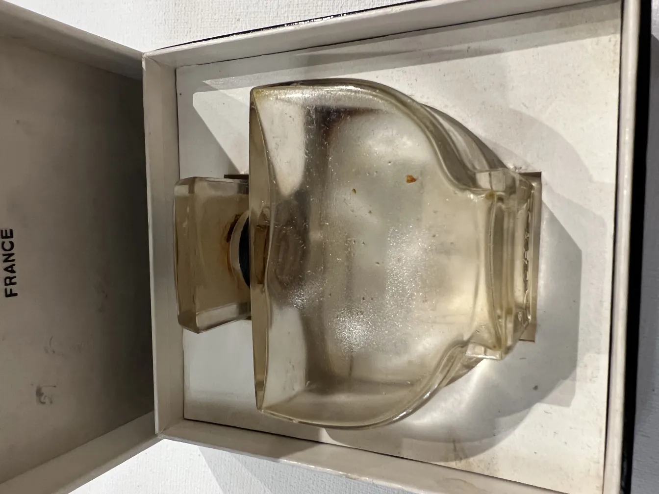 Antike französische Parfümflasche in einer Box, mit sanftem und elegantem Design.