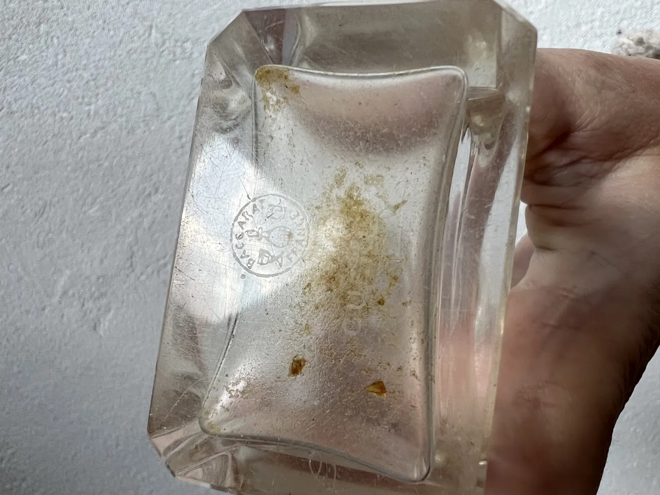 antike Parfümflasche mit rechteckiger Form und Markierungen am Boden