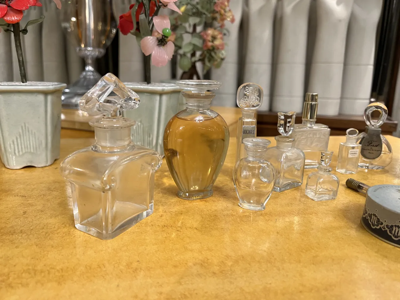 frasco de perfume antigo com várias formas e tamanhos, fundo floral