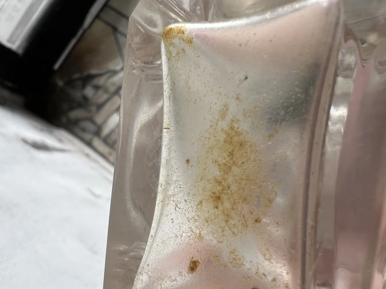 Flacon de parfum ancien avec des détails ornementaux visibles, dans un environnement doux.