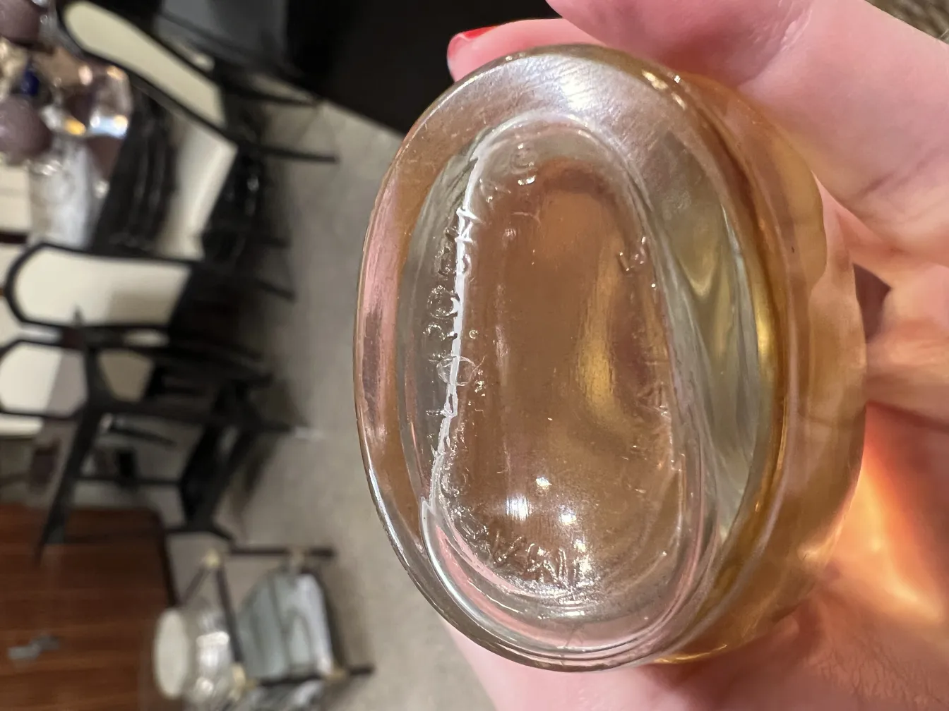 زجاجة عطر قديمة بشكل بيضاوي ولون ذهبي، في بيئة حديثة