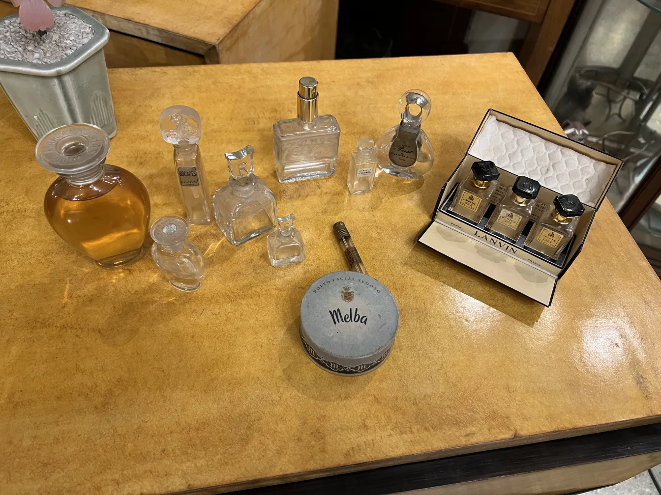 frasco de perfume antiguo en una mesa, varios frascos