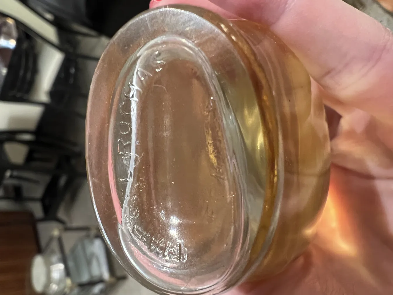 antique translucent perfume bottle in hand, with a faint golden color